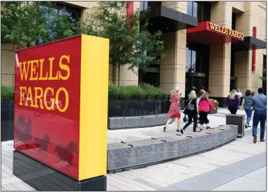  ?? (AP) ?? People pass a Wells Fargo building in downtown Minneapoli­s in this 2019 file photo. The bank said Thursday that it has fired as many as 125 workers for defrauding the Small Business Administra­tion.