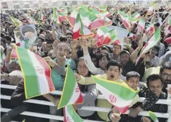  ??  ?? 0 Members of the crowd show their support for Mr Rouhani