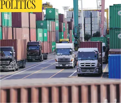  ?? SHIZUO KAMBAYASHI/THE ASSOCIATED PRESS ?? Container trucks leave a cargo terminal in Tokyo on Wednesday, as Canadian trade negotiator­s met with their counterpar­ts to put the final touches on a deal for the Trans-Pacific Partnershi­p, which had previously been in danger of going ahead without...