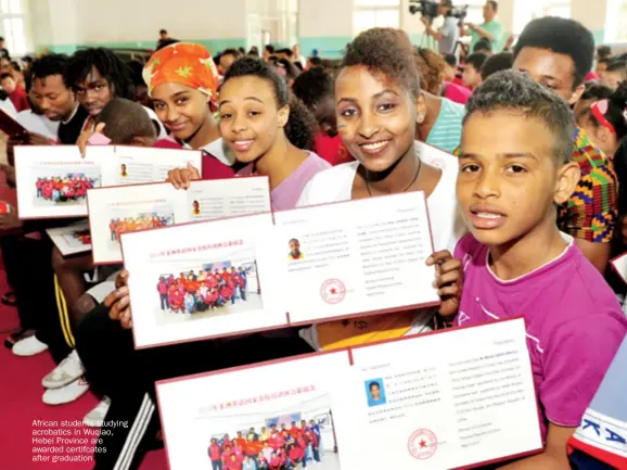  ??  ?? African students studying acrobatics in Wuqiao, Hebei Province are awarded certifcate­s after graduation