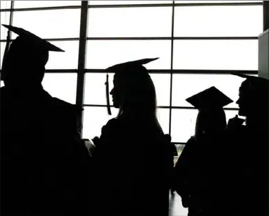  ??  ?? In this Dec. 17, 2006, file photo, Eastern Michigan University graduates socialize before their commenceme­nt at the Convocatio­n Center in Ypsilanti, Mich. In recent years, the Consumer Financial Protection Bureau and the Federal Trade Commission have...