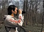  ?? ELIZABETH WRIGHT/AP ?? Law school student Conner Brown looks for birds in Cedar Island, Maryland. He can now identify 30 different species.