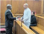  ?? Picture: DEVON KOEN ?? IN THE DOCK: Murder accused Kristen Goeda with his Legal Aid SA attorney, Khaya Saziwa, in the Gqeberha high court. Seated behind him is his co-accused, Asheeka Abrahams