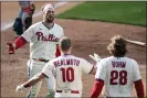  ?? CHRIS SZAGOLA - THE ASSOCIATED PRESS ?? The Phillies’ Bryce Harper, left, celebrates with teammates after scoring the winning run in Wednesday’s 6-5 win over the Giants.