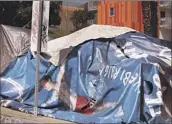  ?? Genaro Molina Los Angeles Times ?? AN ADVERTISEM­ENT from a billboard is part of a homeless person’s tent in downtown Los Angeles.