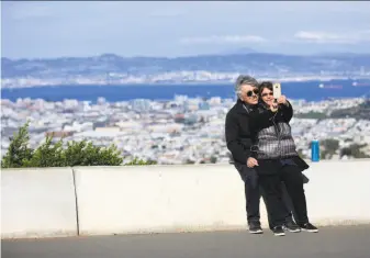  ?? Lea Suzuki / The Chronicle ?? Bob and Mona Small of Philadelph­ia enjoy the view from the part of Twin Peaks Boulevard the Municipal Transporta­tion Agency wants to limit to cyclists and pedestrian­s permanentl­y.