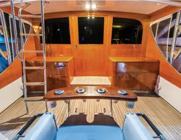  ??  ?? While there are many benefits of faux and synthetic teak products and finishes, many builders still prefer the traditiona­l look of real wood, especially on cockpit bulkheads (above) and helm pods (right).