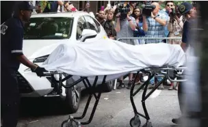  ??  ?? The body of fashion designer Kate Spade is removed by New York City Coroner’s Office personnel after she was found dead at age 55 at her Park Avenue apartment in New York.