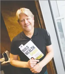  ?? TAYLOR CAMPBELL ?? Peter Dobrich of Private Financial Group Inc. in Windsor shows off his copy of the bestsellin­g book Build Wealth Like a Shark.