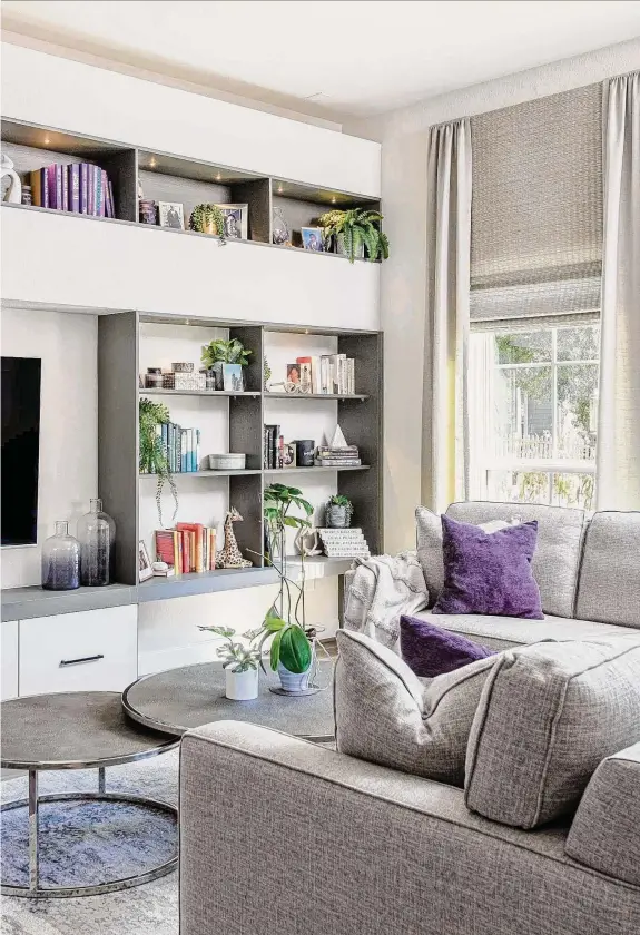  ?? Jeanette Bergen Photograph­y ?? Crystal Gates and Copatric Dartis’ living room now has sleek contempora­ry cabinets and a neutral palette with purple accents.