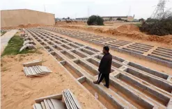  ??  ?? TRIPOLI: A Libyan man walks next to graves dug at the Bir el-Osta Milad cemetery for unidentifi­ed migrants, dubbed by locals as the “cemetery of the unknown”, on the outskirts of the Libyan capital. — AFP