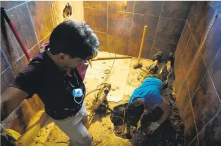  ?? ALEJANDRO TAMAYO U-T ?? Alfredo Ruiz watches another volunteer dig at a house in Tijuana in September where relatives believe the remains of a missing man may be located. Family members of people missing in Mexico have organized into different collective­s to help each other search.
