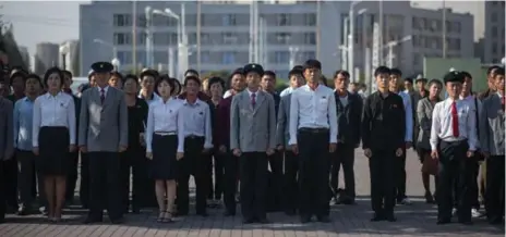  ?? ED JONES/AFP/GETTY IMAGES ?? North Koreans gather to watch Kim Jong Un respond to U.S. President Donald Trump on TVs placed outside Pyongyang’s central railway station.