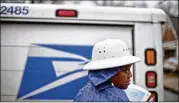  ?? DAVID GOLDMAN / ASSOCIATED PRESS 2014 ?? Letter carrier Jamesa Euler delivers mail in Atlanta. The Postal Service on Thursday reported a quarterly loss of $2.1 billion, compared to a $1.6 billion loss in the same period ending June 30 last year.