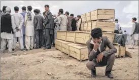  ?? ADAM FERGUSON / NEW YORK TIMES ?? A man weeps alongside empty coffins in Kabul, Afghanista­n, Saturday for victims of a suicide bombing. Suicide bombers targeted a march Saturday in Kabul by the Hazara ethnic minority, killing at least 80 and wounding over 200.