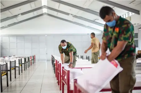  ?? Photo: Leon Lord ?? Republic of Fiji Military Forces personnel setting up beds at Kshatriya Hall, at Desvoux Road, Suva on July 8, 2021, as they prepare for the influx of COVID-19 patents.