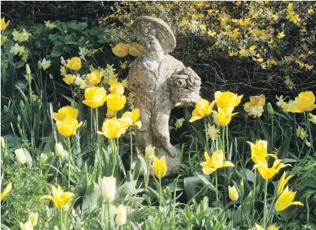  ??  ?? An antique statue anchors flower bed in a garden in Belgium, demonstrat­ing how eye-catching statuary can be used to personaliz­e flower gardens. Garden antiques can be made of wicker, metal or stone and range from pergolas to fountains, outdoor...