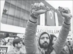  ??  ?? An employee of Zaman newspaper holds a chain during a protest at the courtyard of the newspaper in Istanbul, Turkey. — Reuters photo