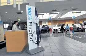  ?? Helen H. Richardson, The Denver Post ?? An electric car charger and a Nissan Leaf, center, are on display in the Tynan’s AutoGroup showroom.