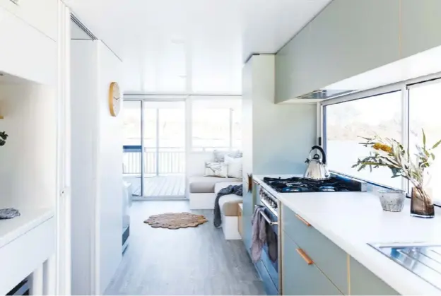  ??  ?? KITCHEN (above) Polyflor Superplank flooring in White Saw Cut Ash draws the eye along the length of the living space and onto the deck beyond. Windows double as a splashback to maximise the light ingress, with integrated and built-in appliances, and full-height cabinetry making the most of the space. READINGNOO­K (opposite, left) Built-in bench seating delivers a quiet corner. KITCHEN DETAIL(opposite, right) A recess cleverly breaks up the wall of cupboards and doors, providing a neat display and prep area.