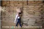  ?? A worker carries a sack of wheat in Ahmedabad ??