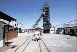  ?? PHOTO: REUTERS ?? Mine workers walk past the pit head at Sibanye Gold’s Masimthemb­e shaft in Westonaria. The mining giant’s negotiatio­ns were hit hard by the promulgati­on of the hew mining charter.