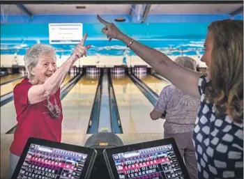  ?? PHOTOGRAPH­S BY ALLEN J. SCHABEN Los Angeles Times ?? LILLIAN SOLOMON is congratula­ted by daughter Rayanne Weiss after bowling a strike during her league match in Torrance. Solomon still lifts weights and drives a convertibl­e. “I love that car,” she says.