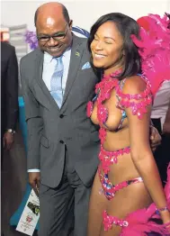 ?? CONTRIBUTE­D PHOTOS ?? Minister of Tourism Edmund Bartlett is all smiles with a costumed model as a sign of things to come for Carnival 2018-19.