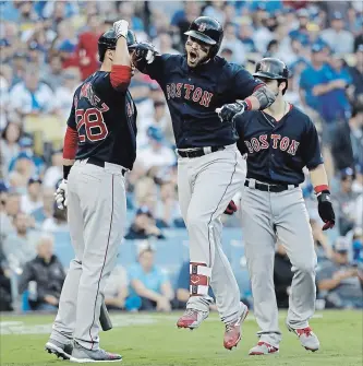  ?? DAVID J. PHILLIP THE ASSOCIATED PRESS ?? Boston Red Sox slugger Steve Pearce celebrates with J.D. Martinez, left, and Andrew Benintendi after hitting a two-run home run during the first inning in Game 5 of the World Series on Sunday night against the Dodgers in Los Angeles. For the game result, see therecord.com.