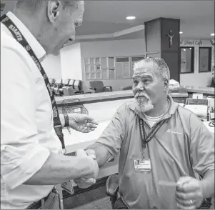  ?? AP PHOTO ?? Robert Tierney Jr., right, a patient registrati­on specialist at Mercy Medical Center, who lost his home in the recent fires, receives a message from Dignity Health North State’s spokesman Mike Mangas, left, that a citizen wants to offer him a place to...