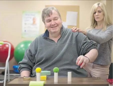  ?? DAX MELMER ?? John Humphrey, who had a stroke at age 15, receives physiother­apy from Ann Marie Keough, a neuro physiother­apist with Enable Neurologic­al Rehabilita­tion. Years of work are starting to pay off for Humphrey, who can now pick up small objects and carry...