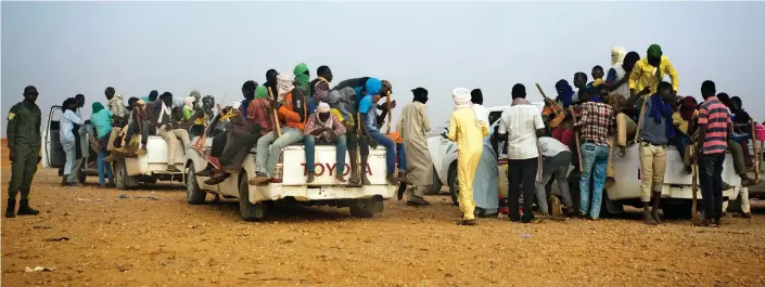  ??  ?? Heading north: Dozens of migrants are loaded on to trucks in Agadez, Niger. Tens of thousands are said to have died trying to cross the Sahara since 2014