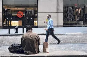  ?? Spencer Platt / Getty Images ?? A man walks in the Financial District in Manhattan on Thursday in New York City. Despite a chaotic political landscape, stocks have been mostly stable with the Dow higher on Thursday.
