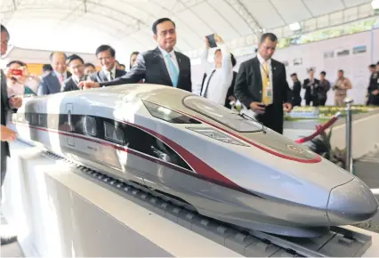  ?? WICHAN CHAROENKIA­TPAKUL ?? Prime Minister Prayut Chan-o-cha inspects a model of the Thai-Sino high-speed railway between Bangkok and Nakhon Ratchasima at the constructi­on inaugurati­on ceremony last December.