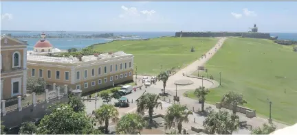  ?? PHOTOS: DANICA COTO/THE ASSOCIATED PRESS ?? Tourists walk through a historic area of Puerto Rico’s capital in San Juan. The U.S. territory’s historic buildings are decaying as public and private funding for maintenanc­e, repairs and restoratio­n is slashed amid a debt crisis and recession.