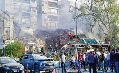  ?? FOTO: ?? CAOS. Gente se reunió cerca del edificio destruido atacado por aviones israelíes en Damasco.
AP