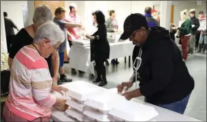  ?? The Sentinel-Record/Tanner Newton ?? MEALS TO GO: Volunteers at Visitors Chapel AME Church stack meals that were then delivered around town on Thanksgivi­ng.