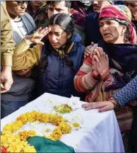  ??  ?? NATION'S PRIDE: CRPF Jawan Mohan Lal's daughter and wife with his body in Dehradun on Saturday