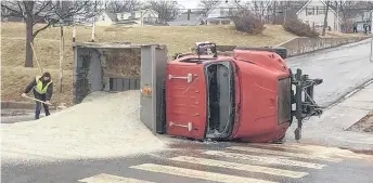  ?? CONTRIBUTE­D/NGRP ?? This salt truck tipped over after sliding down a street in Trenton on Friday morning because of icy conditions.