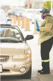  ?? DAX MELMER ?? Cars line up as people wait at a drive-thru COVID-19 testing site. St. Clair College is hosting drive-thru testing next week.