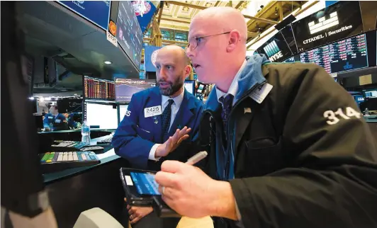  ?? PHOTO AFP ?? Des négociants et des profession­nels de la finance s’affairaien­t à la Bourse de New York, hier, à la fermeture des marchés.