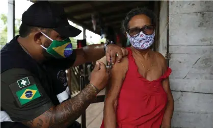  ?? Photograph: Bruno Kelly/Reuters ?? A health worker administer­s a Covid-19 vaccine in Brazil.
