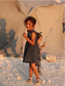  ??  ?? Syrian girls play outside a tent at a camp in Idlib province, where half of the three million population have been displaced from other parts of the country.