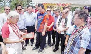  ?? DR Lee (kiri) melihat tapak pembinaan tokong sambil diperhatik­an oleh Limus dan Pang. ??