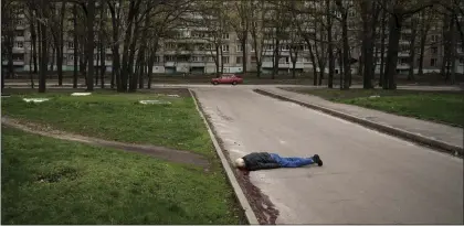  ?? FELIPE DANA — THE ASSOCIATED PRESS ?? The body of a man killed during a Russian bombardmen­t lies on a street at a residentia­l neighborho­od in Kharkiv, Ukraine, Tuesday, April 19, 2022.