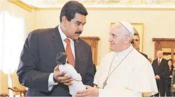  ??  ?? Nicolás Maduro entrega al Papa Francisco una estatuilla de José Gregorio Hernández, una figura popular entre los venezolano­s, en su visita al Vaticano, en 2013.