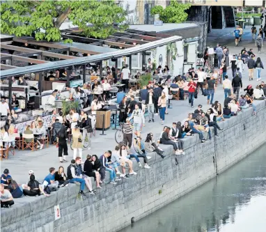  ?? [Clemens Fabry] ?? Am Ufer des Donaukanal­s sitzen Jugendlich­e bereits. Auch die Lokale erwachen aus dem Winterschl­af.