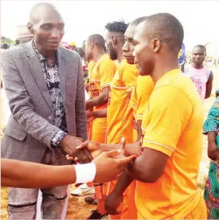  ??  ?? Sponsor of the tournament, Comrade Ekene Abubakar Adams shaking hands with players of Sabo Gunners before their opening match with Sambo Bombers. Sabo Gunners won 3-0.