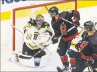  ?? Chris Young / Associated Press ?? Boston Bruins goaltender Jaroslav Halak (41) eyes the puck in front of the Carolina Hurricanes’ Vincent Trocheck as the Hurricanes’ Jordan Staal (11) looks on during the third period on Saturday.