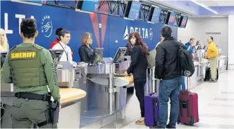  ?? JOE CAVARETTA/STAFF PHOTOGRAPH­ER ?? Passengers check in at the Delta Air Lines counter at Fort Lauderdale Hollywood Internatio­nal Airport on Tuesday.